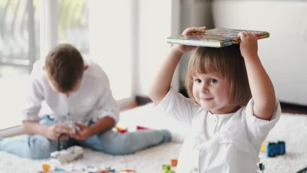 Ritratto di bambina con libro in mano a casa — Video Stock