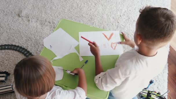 Dos niños dibujando con lápices de colores juntos en casa — Vídeos de Stock