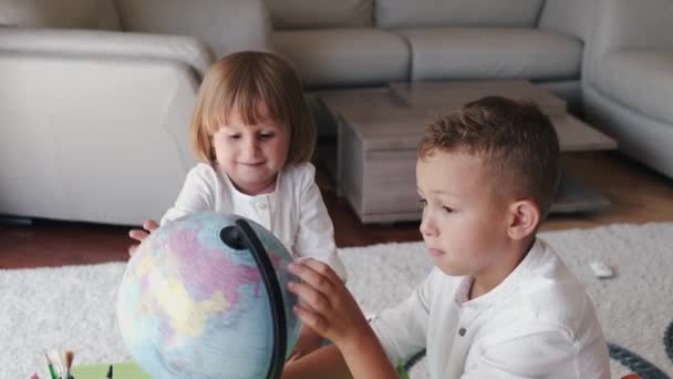 Fratello e sorella esplorare mondo con globo insieme a casa — Video Stock