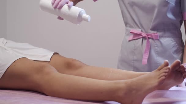 Esthéticienne utilisant pulvérisation avant la procédure d'épilation dans salon — Video