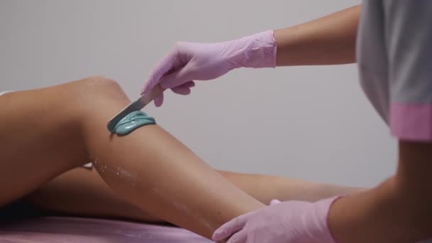 Kosmetikerin setzt im Schönheitssalon Paste auf Frauenbein — Stockvideo