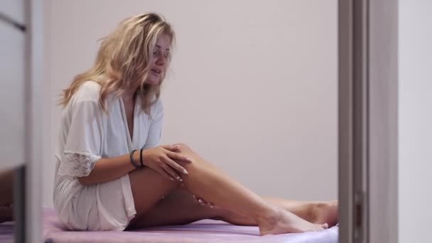 Mulher tocando suas pernas lisas após o procedimento de depilação no salão — Vídeo de Stock