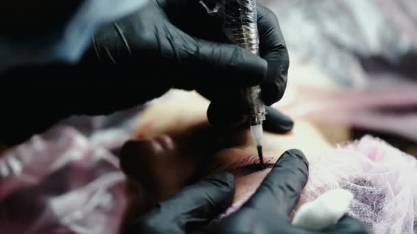 El artista profesional de la frente está haciendo microblading en las cejas — Vídeo de stock