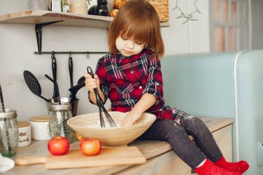 Mutfakta oturan tatlı küçük kız.