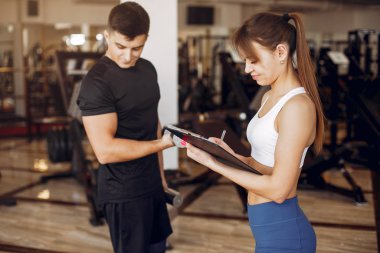 Güzel bir spor çifti bir spor salonunda nişanlanıyor.