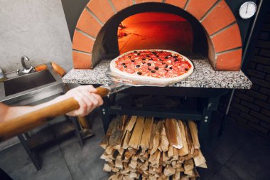 Mutfakta şef pizza hazırlıyor.