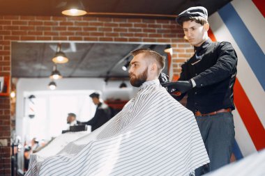 Berber dükkanında oturan şık bir adam.