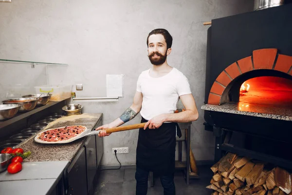 Koch in der Küche bereitet Pizza zu — Stockfoto