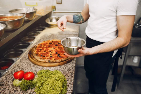 Koch in der Küche bereitet Pizza zu — Stockfoto