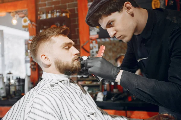 Elegante hombre sentado en una barbería — Foto de Stock