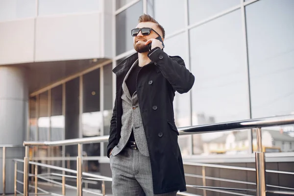 Handsome businesman in a summer city — Stock Photo, Image