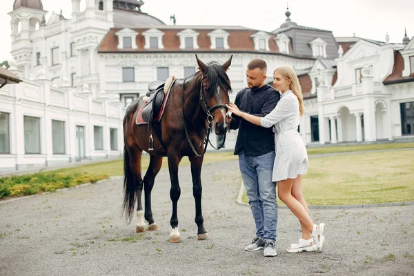 Söta kärleksfulla par med häst på ranch — Stockfoto