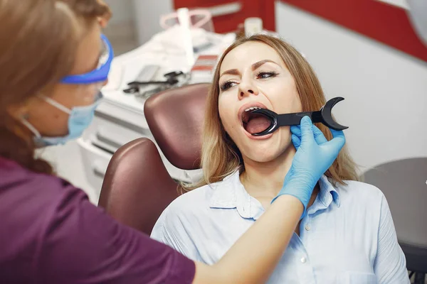 Menina bonita sentada no escritório de dentistas — Fotografia de Stock