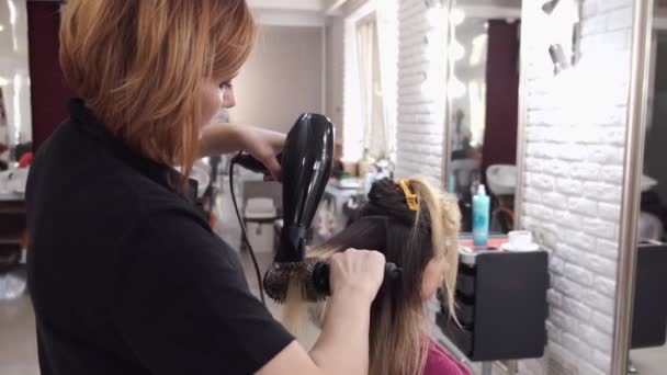 Professioneller Friseur trocknet Damenhaare im Schönheitssalon — Stockvideo