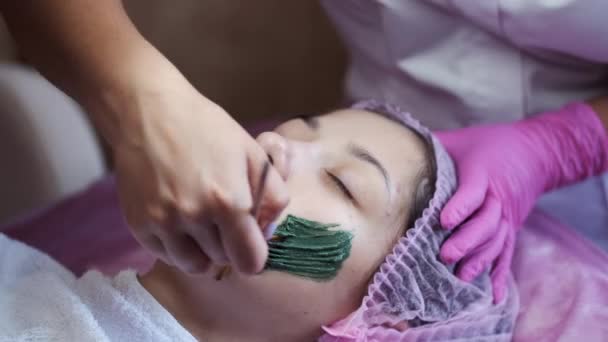 Vue recadrée du processus de mise masque sur le visage des clients dans le salon — Video