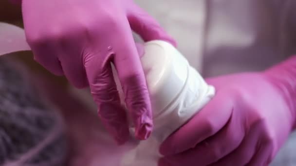 Cosmetoloog neemt gezichtscrème voor het doen van huidreiniging — Stockvideo