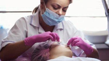 Cosmetologist doing manual facial cleansing in beauty salon