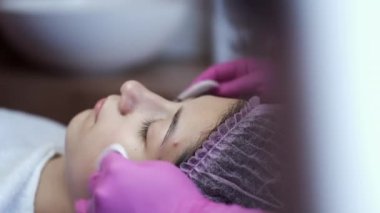 Cosmetologist doing manual facial cleansing in beauty salon