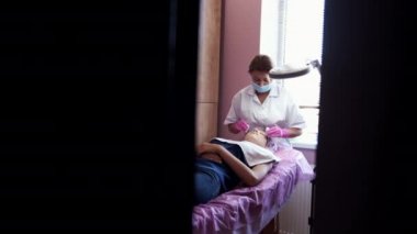 Cosmetologist doing manual face massage in beauty salon