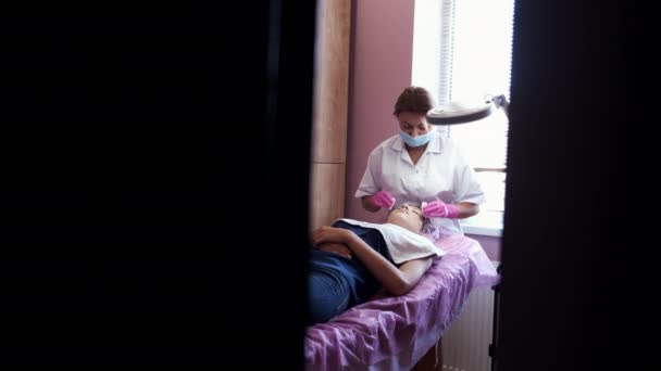 Косметолог делает массаж лица вручную в салоне красоты — стоковое видео