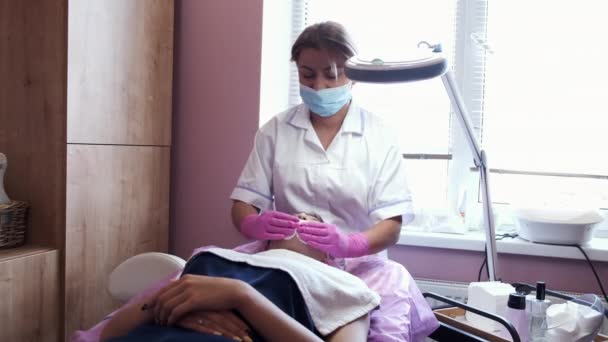 Cosmetólogo haciendo masaje facial manual en salón de belleza — Vídeo de stock
