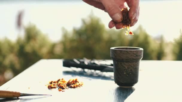 Обрезанный вид на приготовление табака для шиши на столе снаружи — стоковое видео