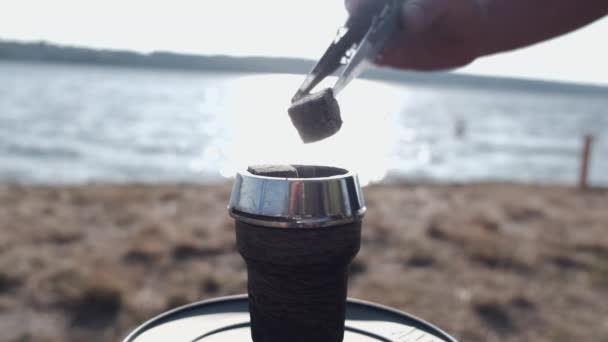 Cropped view of process of lighting coal in hookah outside — Stock Video