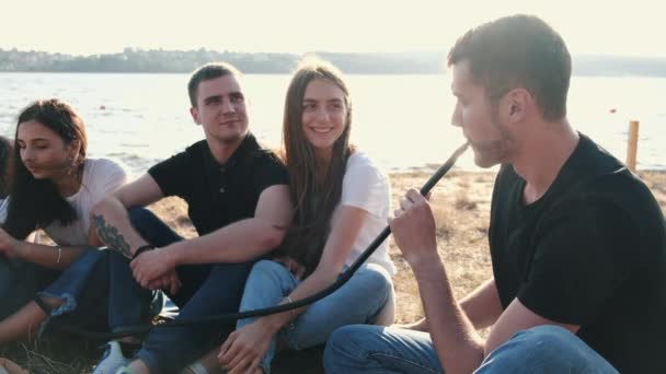 Group of young people sitting outside smoking shisha — 图库视频影像