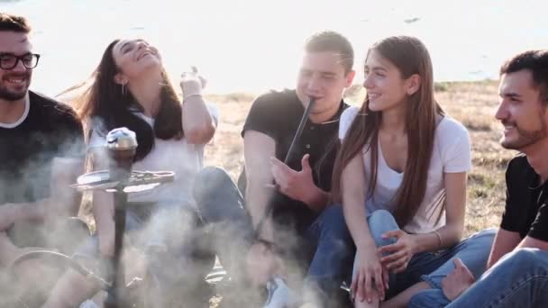 Grupa młodych ludzi siedzących poza paleniem shisha — Wideo stockowe