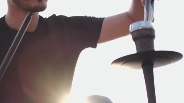 Бородатый мужчина чинит кальян для клиентов на улице летом — стоковое видео