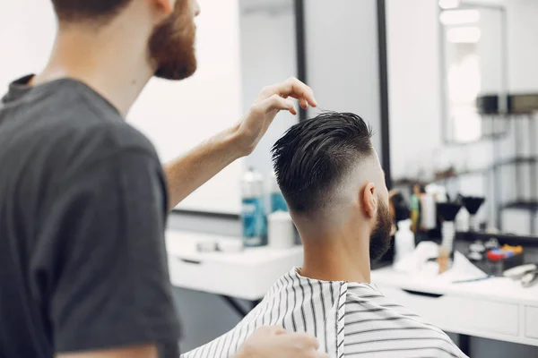 Stilvoller Mann sitzt in einem Friseurladen — Stockfoto