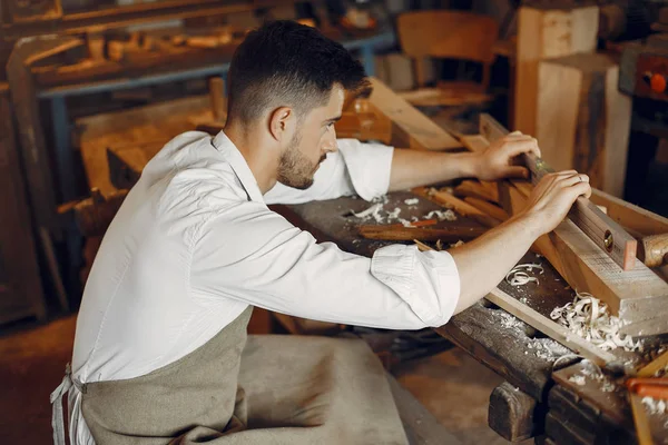 Tahtayla çalışan yakışıklı marangoz.