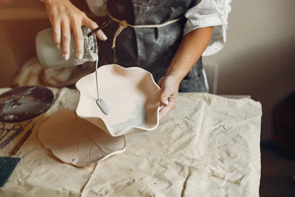 Une jeune femme fait des plats dans une poterie — Photo