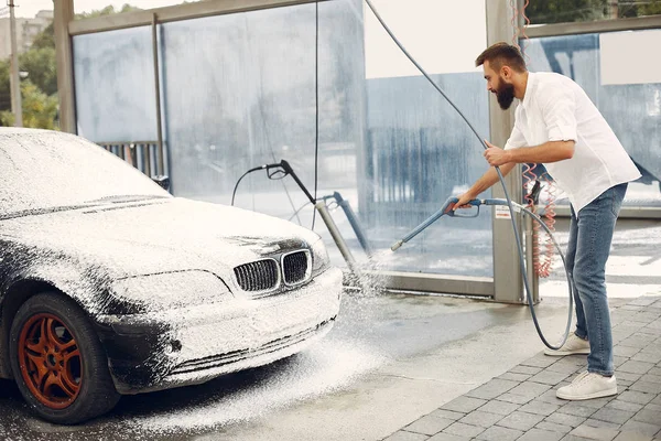 Seorang pria mencuci mobilnya di tempat cuci — Stok Foto
