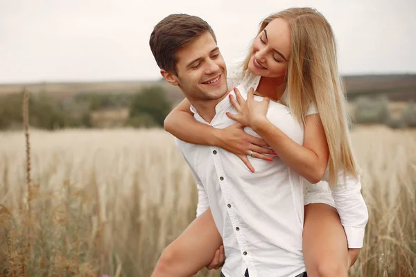 Beautiful couple spend time in a autumn field — Stock Photo, Image