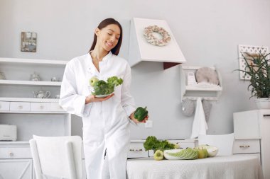 Doctor in a kitchen with a vegetables