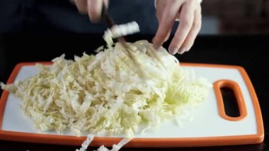 The cauliflower is being cut on a cutting board