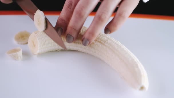 Szef kuchni kroi banana na desce do krojenia. — Wideo stockowe