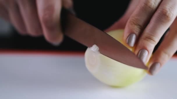 The onion is being sliced with a knife — Stok video