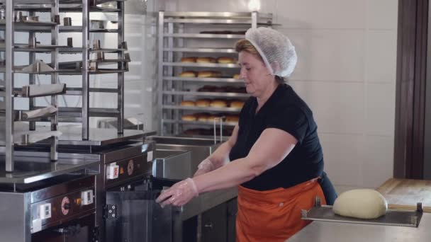 The woman chef is putting the dough into a fridge — Stok video