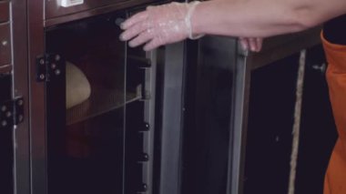 The chef is getting the grown dough out of a fridge.