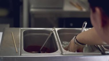 The chef is putting a donut in the milky glaze.