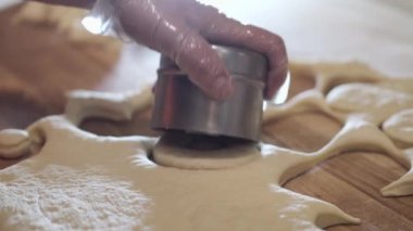 The chef is cutting the donut pastry into round shapes