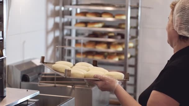 Die Köchin dreht die Donut-Basen vor dem Braten auf eine andere Seite — Stockvideo