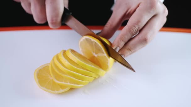 Апельсин розрізають на обробній дошці — стокове відео