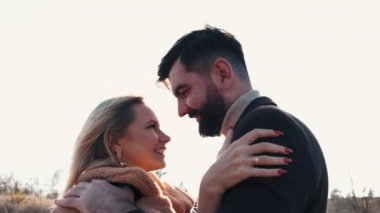 Bir çift erkek ve bir kadın gün batımında birlikte eğleniyorlar.