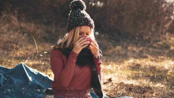 The woman is opening a flask and drinking coffee from a cap — Stock Video