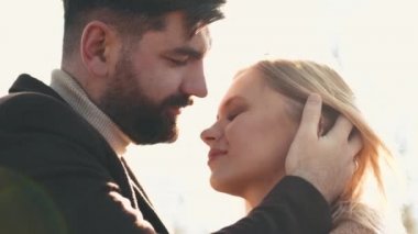 Esmer bir adamla sarışın bir kadın gün batımında birlikte vakit geçiriyorlar.