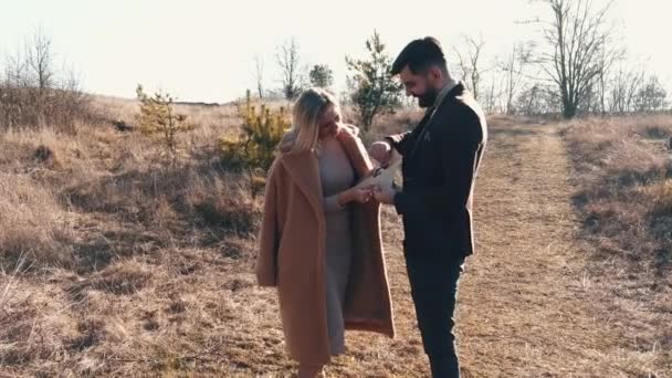 La pareja de hombres y una mujer está al aire libre disfrutando del tiempo juntos al atardecer — Vídeo de stock