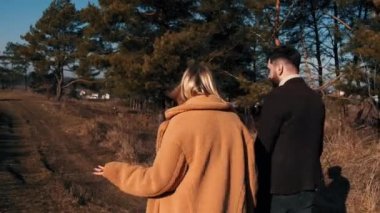 Sevgili çift sonbaharda orman yolunda yürüyor.